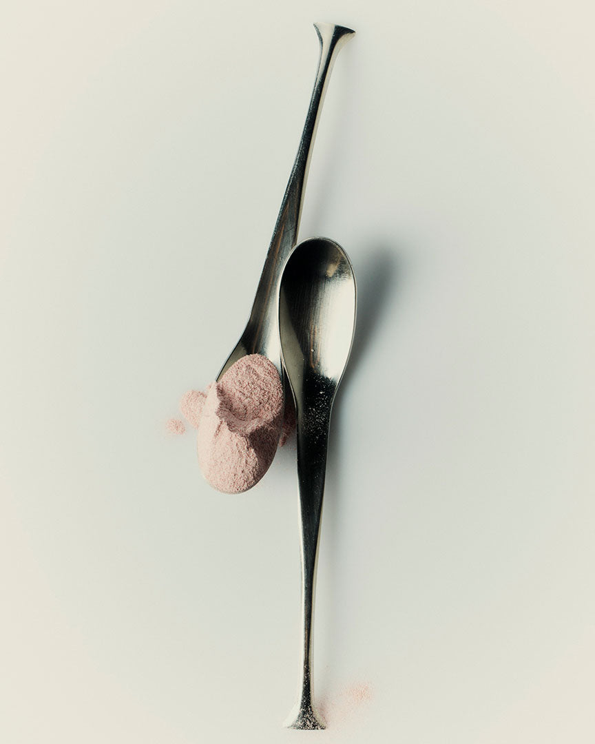 Pink CALM/SLEEP powder balanced on two polished spoons