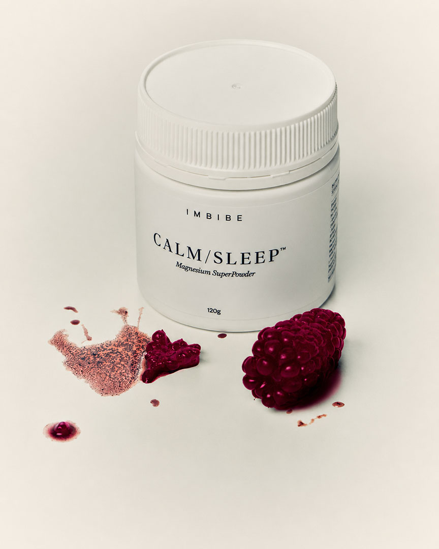 A 120g CALM/SLEEP jar beside a raspberry and a dusting of pink powder